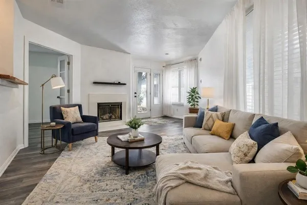 a living room with furniture a fireplace and a window