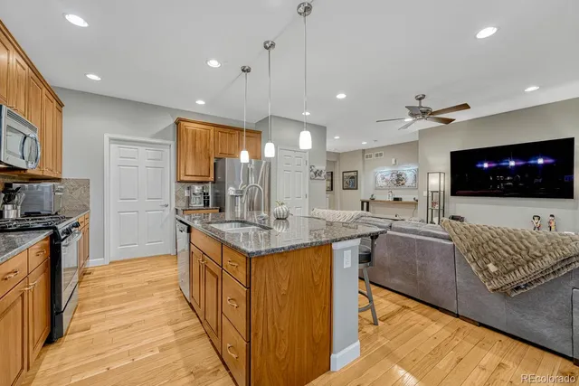 a open kitchen with stainless steel appliances granite countertop a stove and a sink