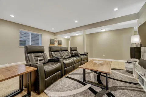 a media room with lots of chairs and a wooden floor