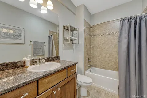 a bathroom with a granite countertop sink toilet and shower