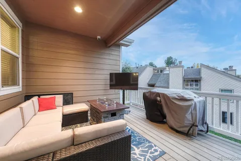 a view of a deck with couches table and chairs with wooden floor