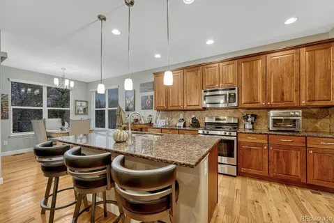 a kitchen with kitchen island granite countertop wooden cabinets and stainless steel appliances