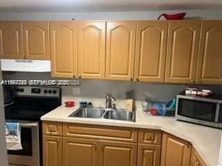 3253 Foxcroft Road, Unit G107 Miramar, FL 33025 - Photo 7 of 10 a kitchen with stainless steel appliances granite countertop a sink a stove and cabinets