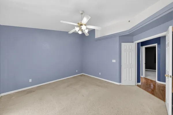 a view of an empty room with a chandelier fan