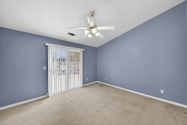 en empty room with windows and ceiling fan