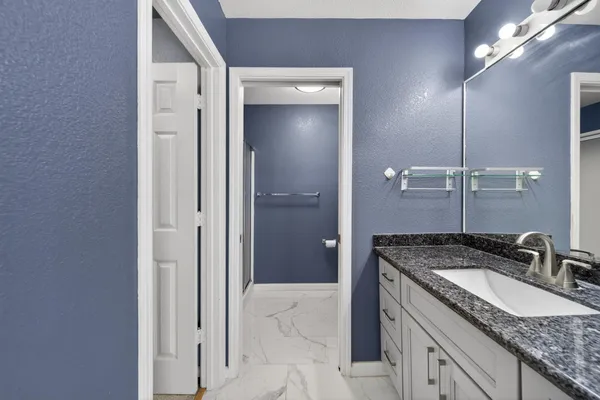 a bathroom with a granite countertop sink and a mirror