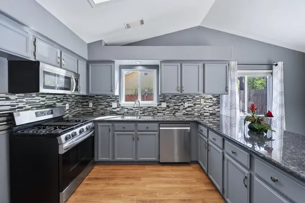 a kitchen with stainless steel appliances granite countertop a sink and stove top oven