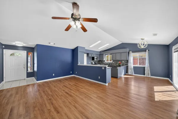 a bedroom with kitchen ceiling fan and wooden floor