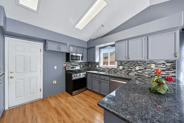 a kitchen with granite countertop stainless steel appliances and wooden cabinets