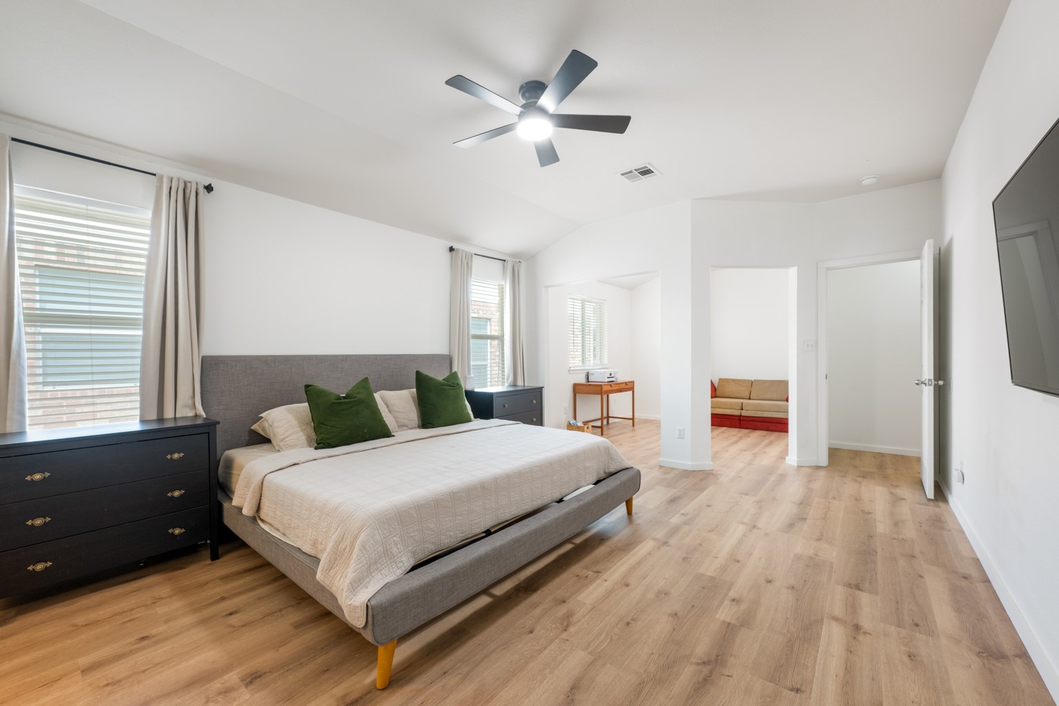 1391 Stone Rim Loop Buda, TX 78610 - Photo 16 of 35 A generous primary bedroom suite features rich wood flooring and a stylish ceiling fan.