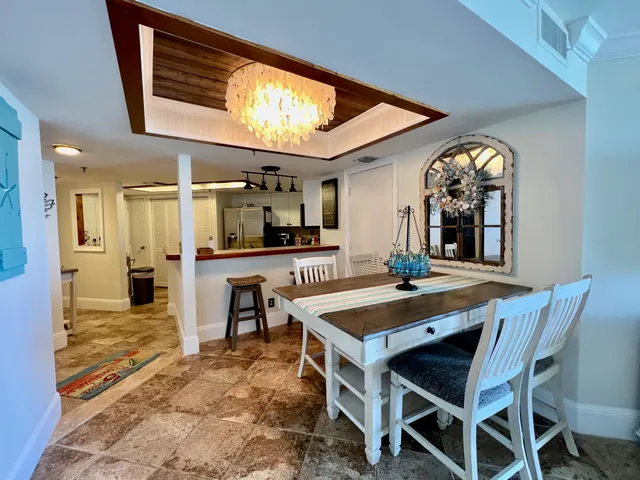 a view of a dining room with furniture and a kitchen view
