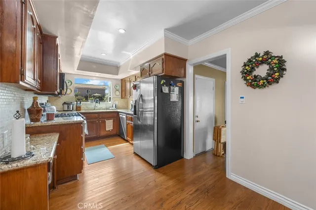 a kitchen with stainless steel appliances granite countertop a refrigerator and a sink