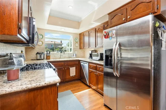 a kitchen with stainless steel appliances granite countertop a sink a stove and a refrigerator