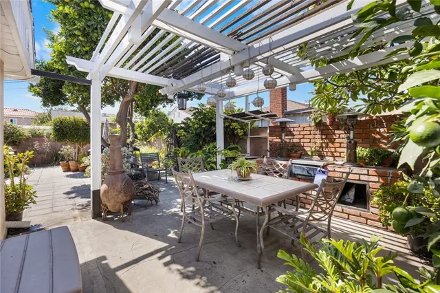 a view of a patio with table and chairs potted plants and large tree