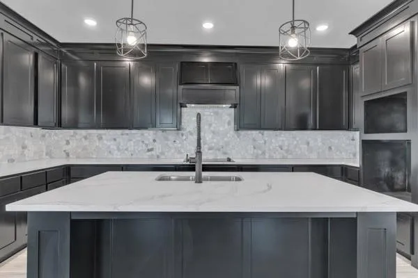 a kitchen with a sink a counter space appliances and cabinets