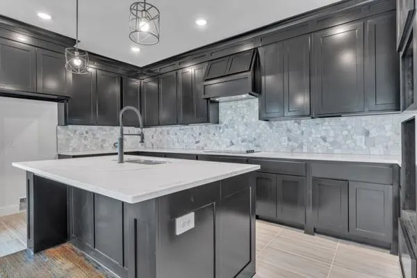 a kitchen with kitchen island a sink stainless steel appliances and cabinets