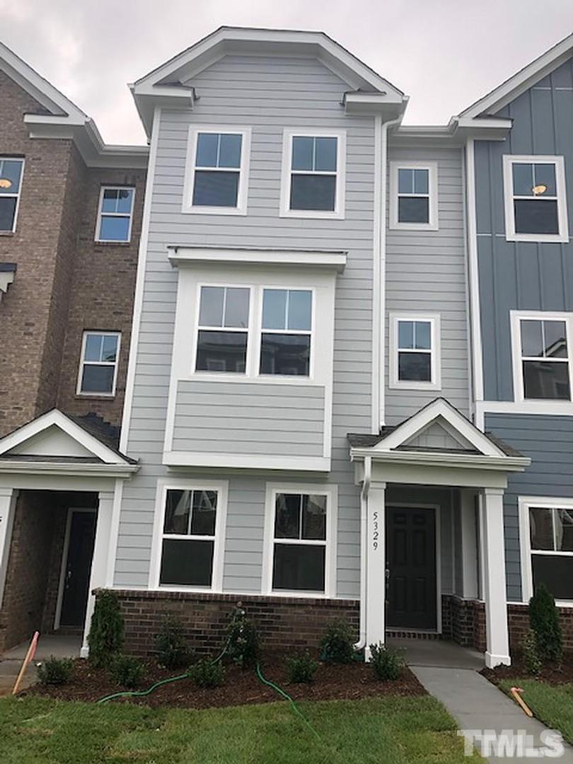 a front view of a house with a yard and porch