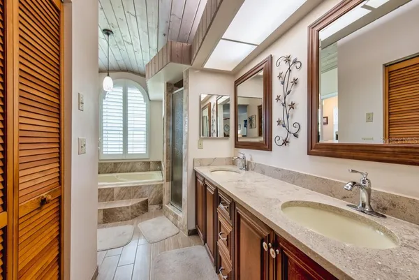 a bathroom with a granite countertop sink and a large mirror