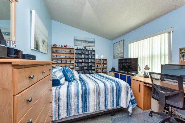 a bedroom with a bed and a computer on the desk