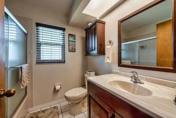 a bathroom with a granite countertop sink mirror vanity and toilet