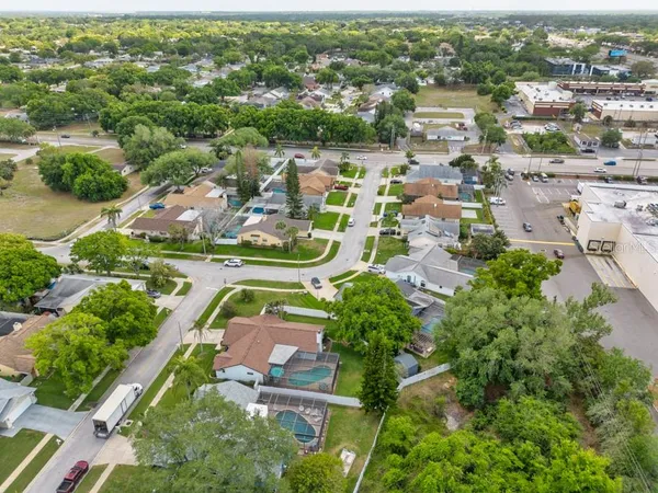 an aerial view of residential houses with outdoor space and trees