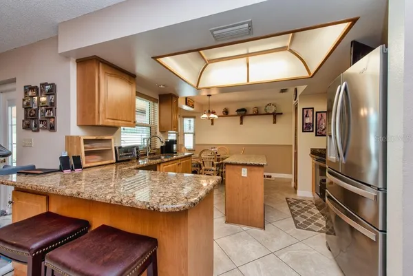 a kitchen with stainless steel appliances granite countertop a sink refrigerator and microwave