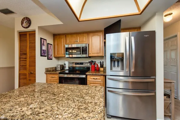 a kitchen with granite countertop stainless steel appliances and wooden cabinets