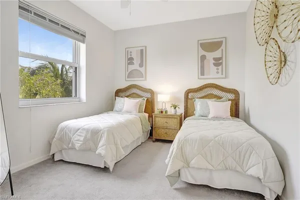 a bedroom with two beds and painting on the wall
