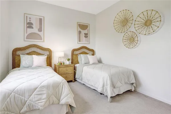 a bedroom with two beds and a chair