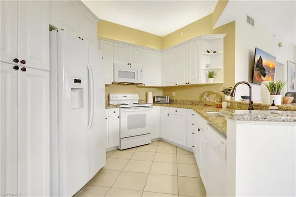 a kitchen with white cabinets and white appliances