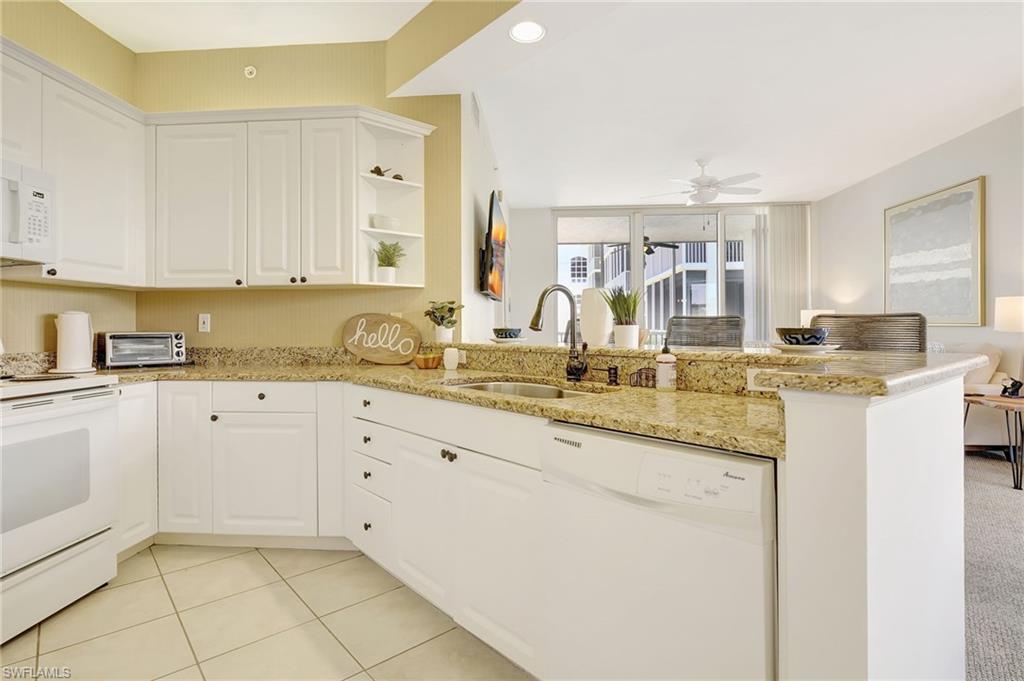 470 Launch Circle, Unit V405 Naples, FL 34108 - Photo 6 of 41 a kitchen with granite countertop a sink and cabinets