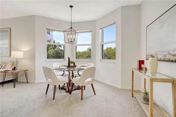 a dining room with furniture a chandelier and window