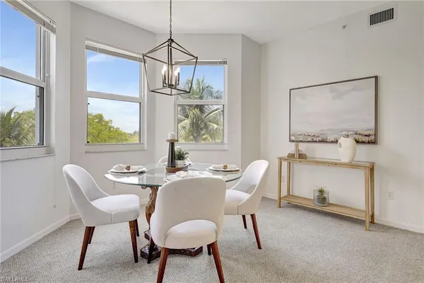a dining room with furniture a chandelier and wooden floor