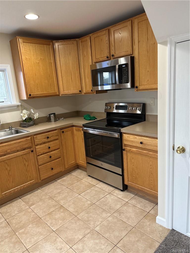 100 Dunderberg Road Putnam Valley, NY 10579 - Photo 10 of 29 a kitchen with stainless steel appliances granite countertop a stove microwave and sink