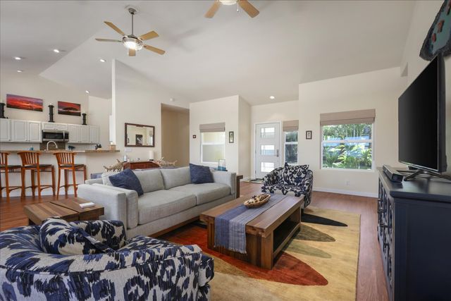 a living room with furniture a large window and a flat screen tv