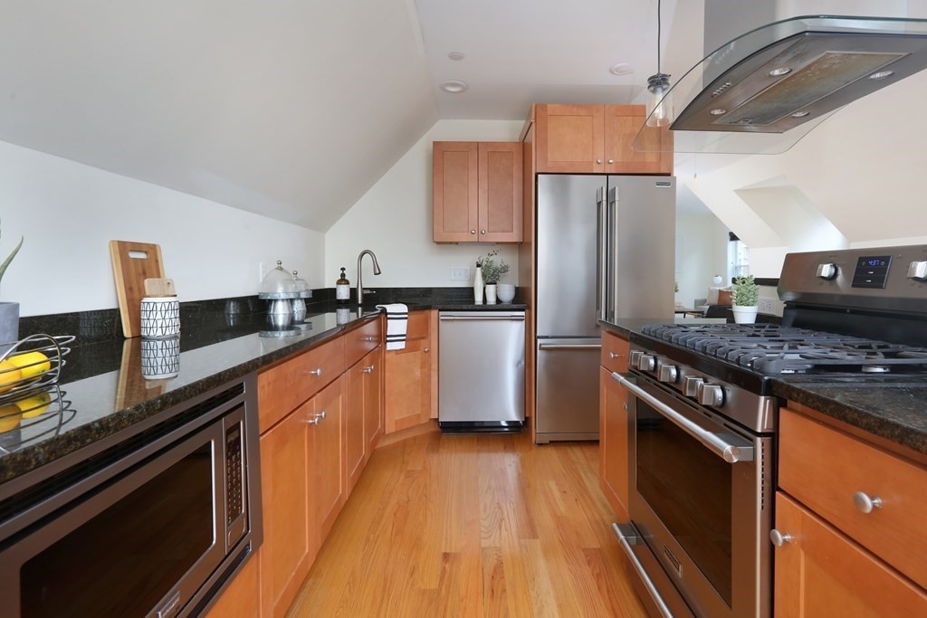 150 Lowell Street, Unit 3 Somerville, MA 02143 - Photo 3 of 12 a kitchen with stainless steel appliances granite countertop a sink stove and refrigerator