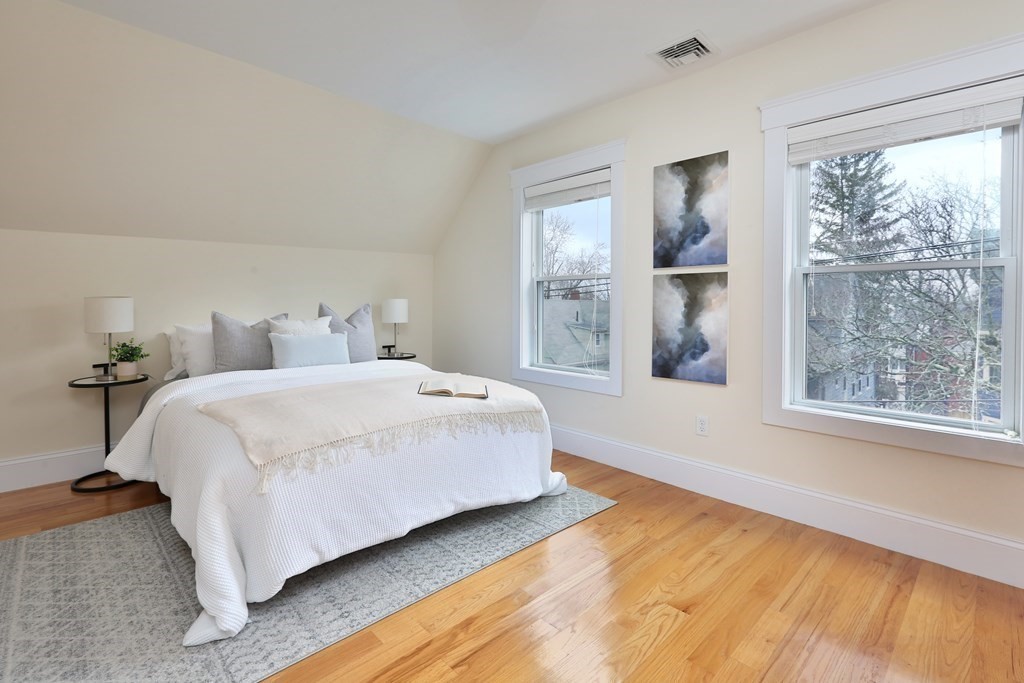 150 Lowell Street, Unit 3 Somerville, MA 02143 - Photo 8 of 12 a bedroom with a bed and a large window