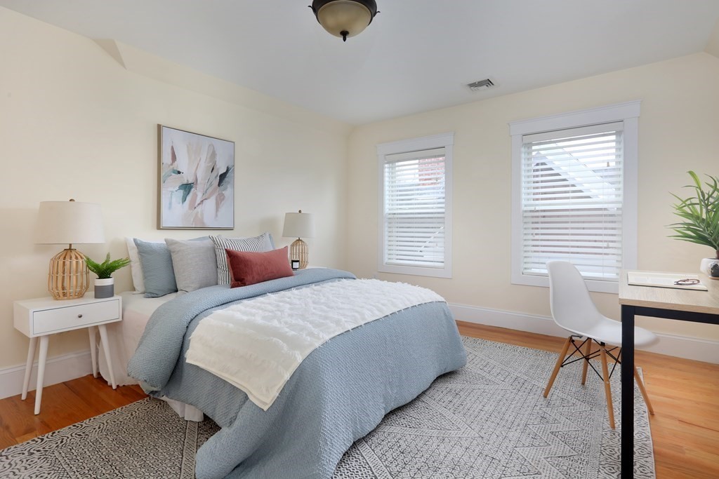 150 Lowell Street, Unit 3 Somerville, MA 02143 - Photo 9 of 12 a bedroom with a bed and wooden floor