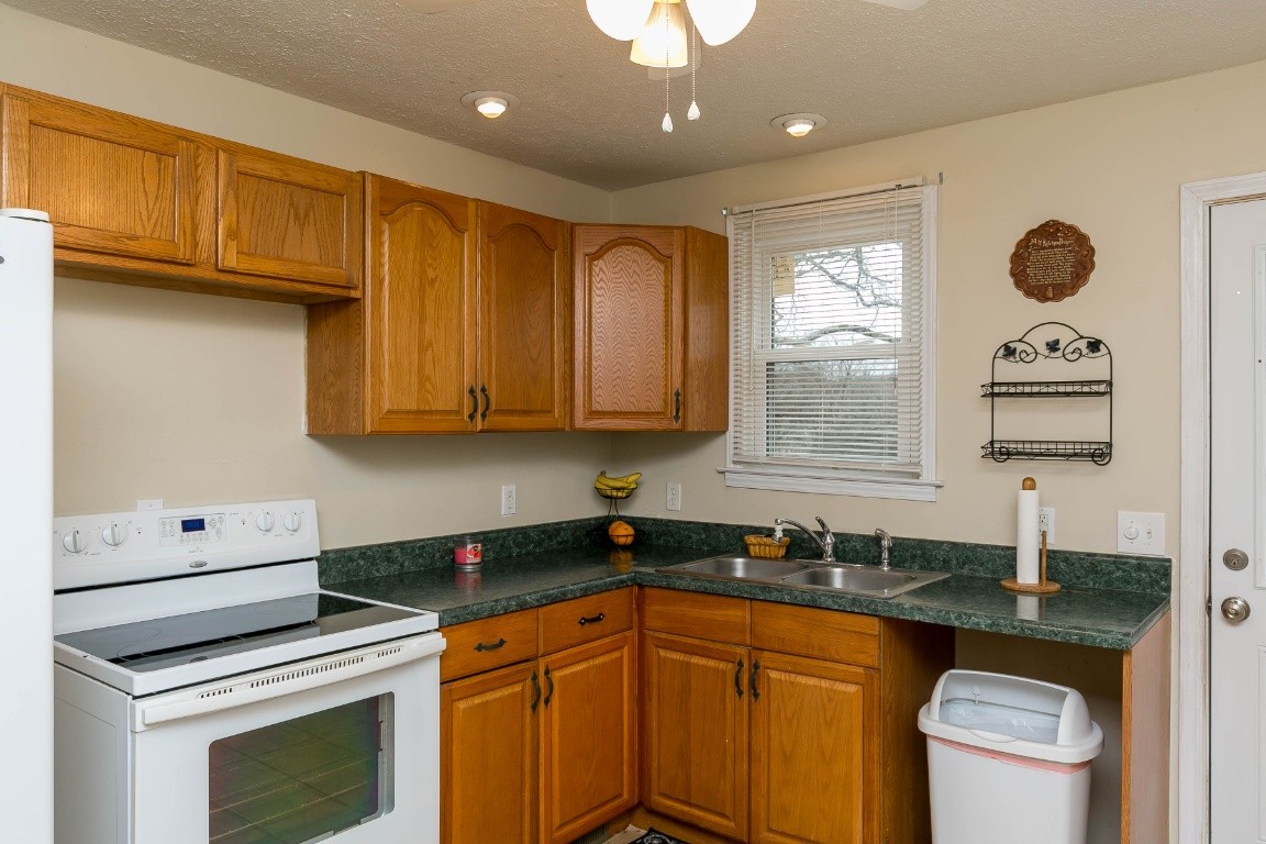 304 Randy Road Madison, TN 37115 - Photo 11 of 34 a kitchen with stainless steel appliances granite countertop a sink a stove a washer dryer and cabinets