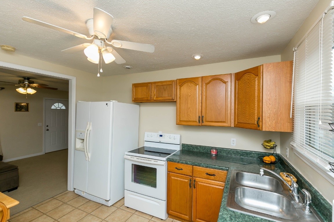 304 Randy Road Madison, TN 37115 - Photo 14 of 34 a kitchen with stainless steel appliances granite countertop a refrigerator a sink dishwasher a stove top oven a washer and dryer with wooden floor