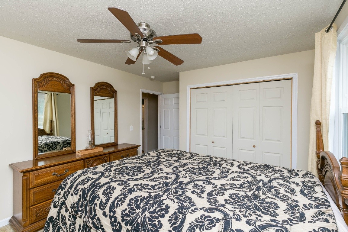 304 Randy Road Madison, TN 37115 - Photo 19 of 34 a bedroom with a large bed and a chandelier