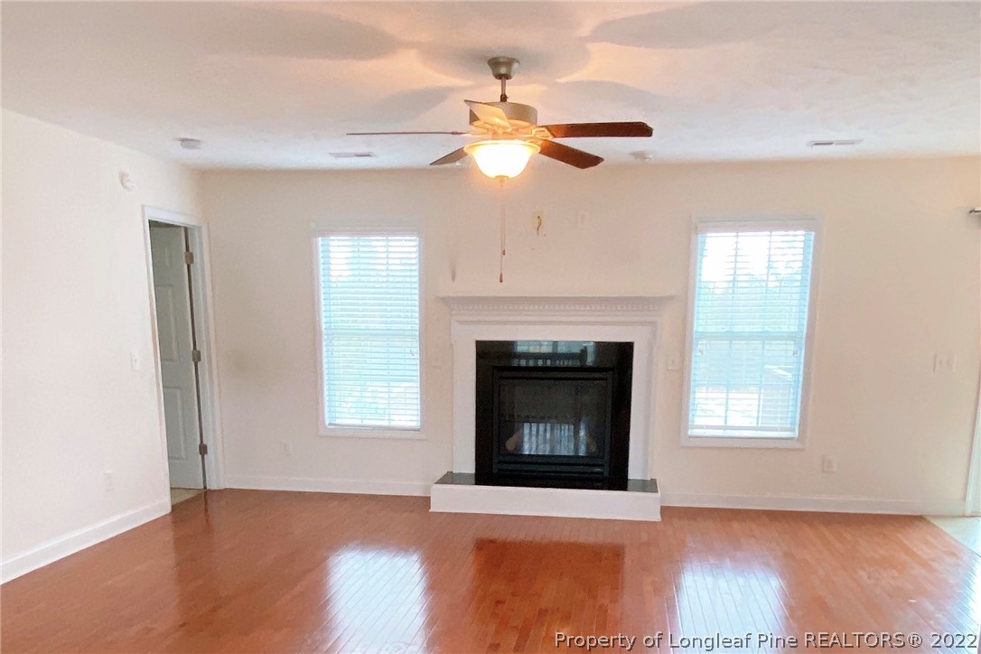 30 Hanson Court Bunnlevel, NC 28323 - Photo 3 of 4 a living room with a fireplace ceiling fan and wooden floor