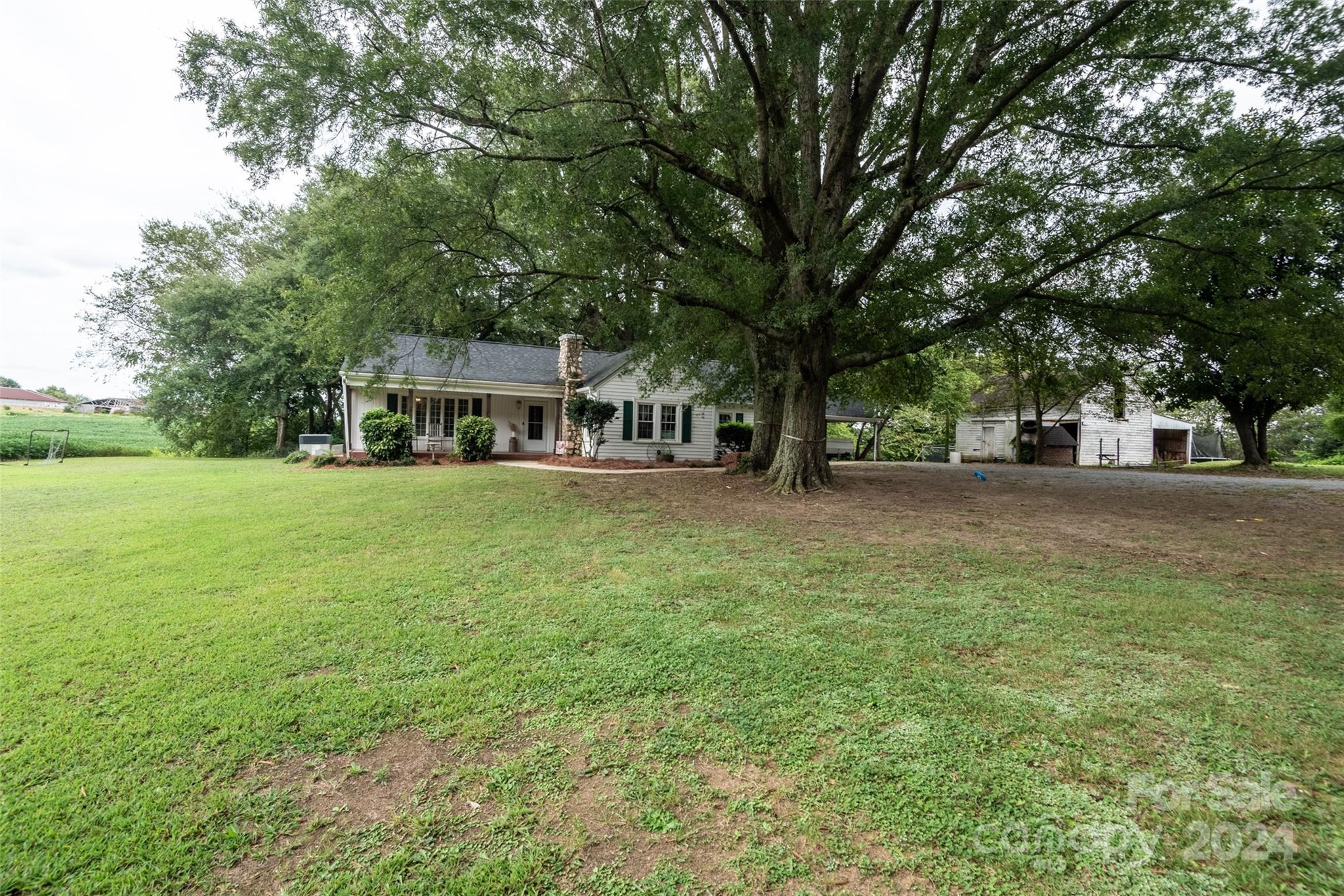 3913 Belk Mill Road Monroe, NC 28112 - Photo 2 of 25 a view of a house with a big yard and large trees