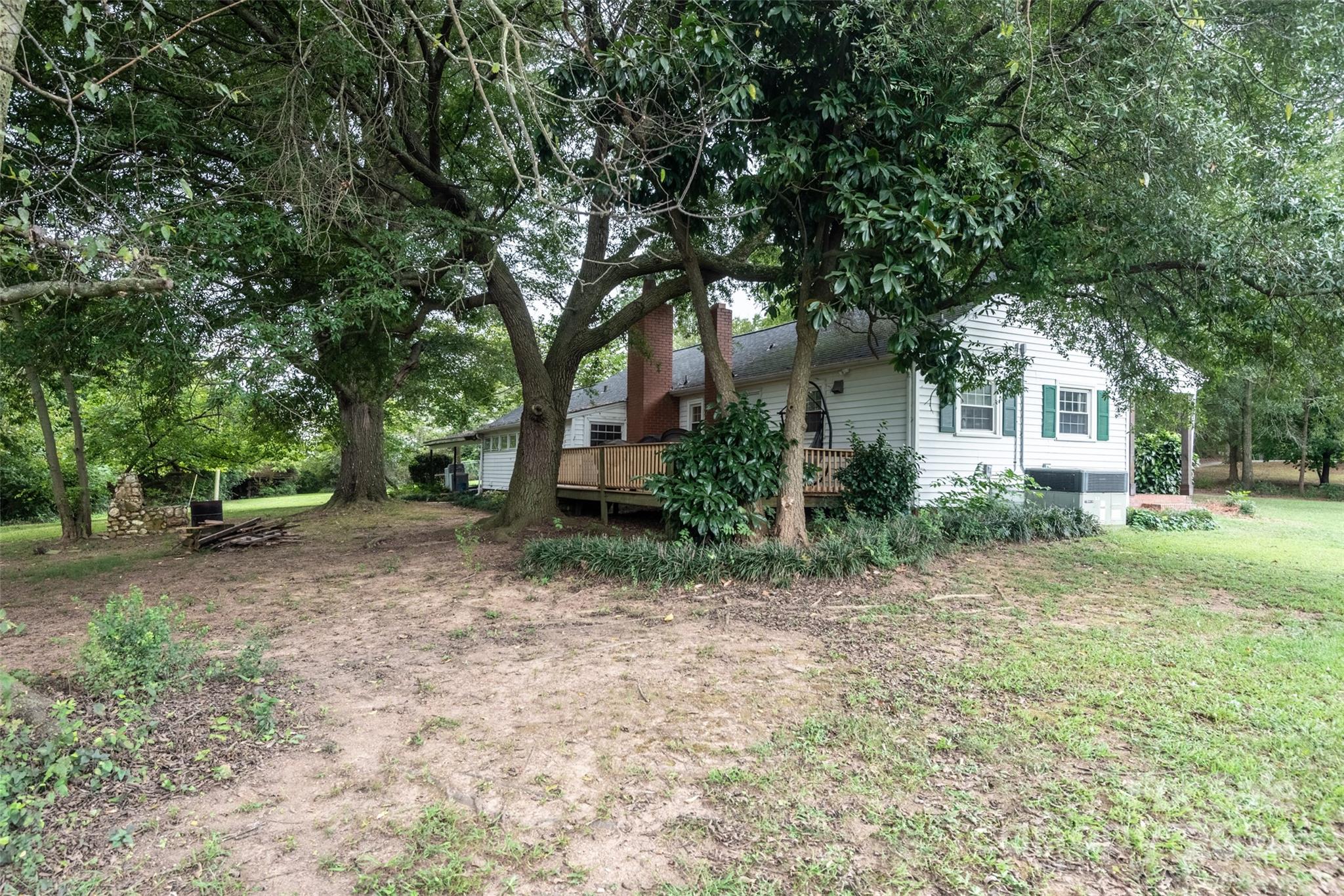 3913 Belk Mill Road Monroe, NC 28112 - Photo 21 of 25 a backyard of a house with plants and large tree