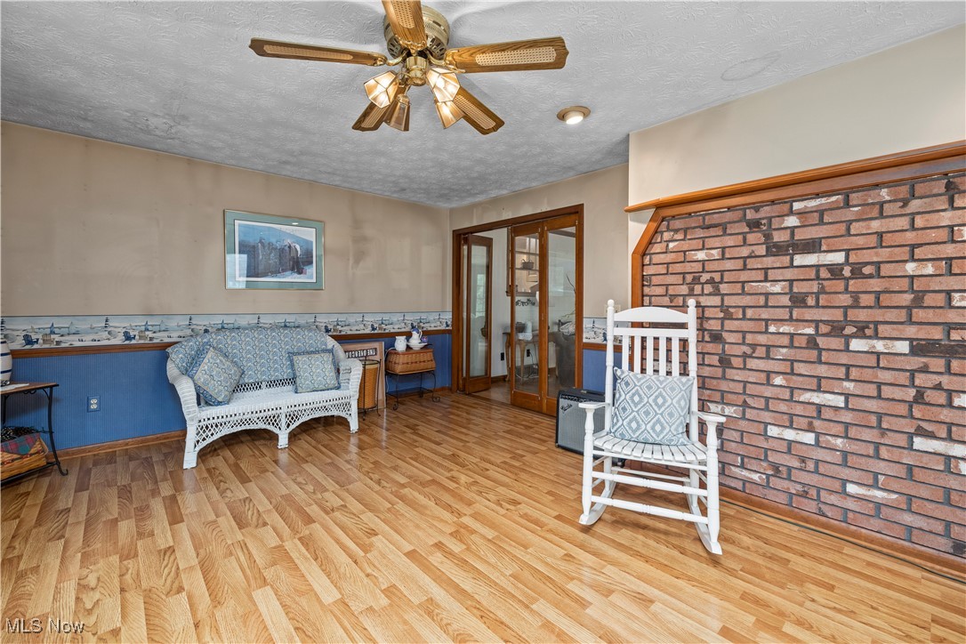 11811 Robson Road Grafton, OH 44044 - Photo 21 of 50 Living area featuring wood finished floors, ceiling fan, a textured ceiling, french doors, and a wainscoted wall