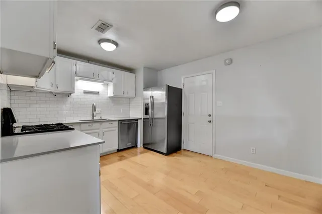 a kitchen with a refrigerator sink stove and cabinets