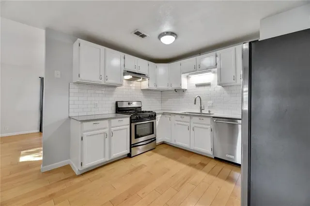 a kitchen with granite countertop white cabinets and white appliances