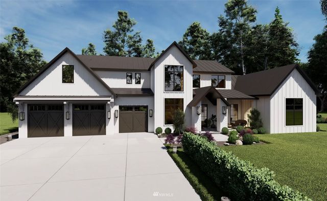 a view of a white house with large windows and a small yard