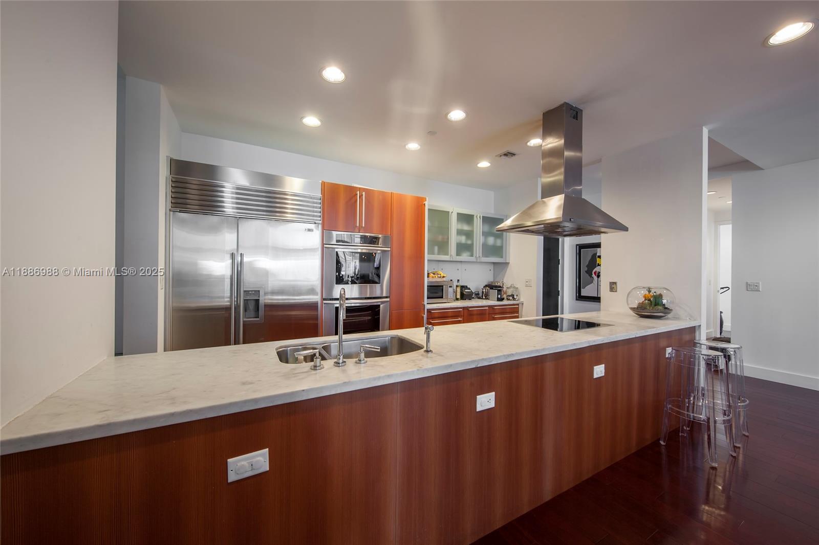 201 Aqua Avenue, Unit 1004 Miami Beach, FL 33141 - Photo 4 of 7 a kitchen with stainless steel appliances a sink and a refrigerator