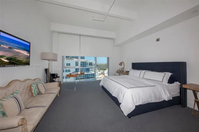 a bedroom with a bed couch and a flat screen tv